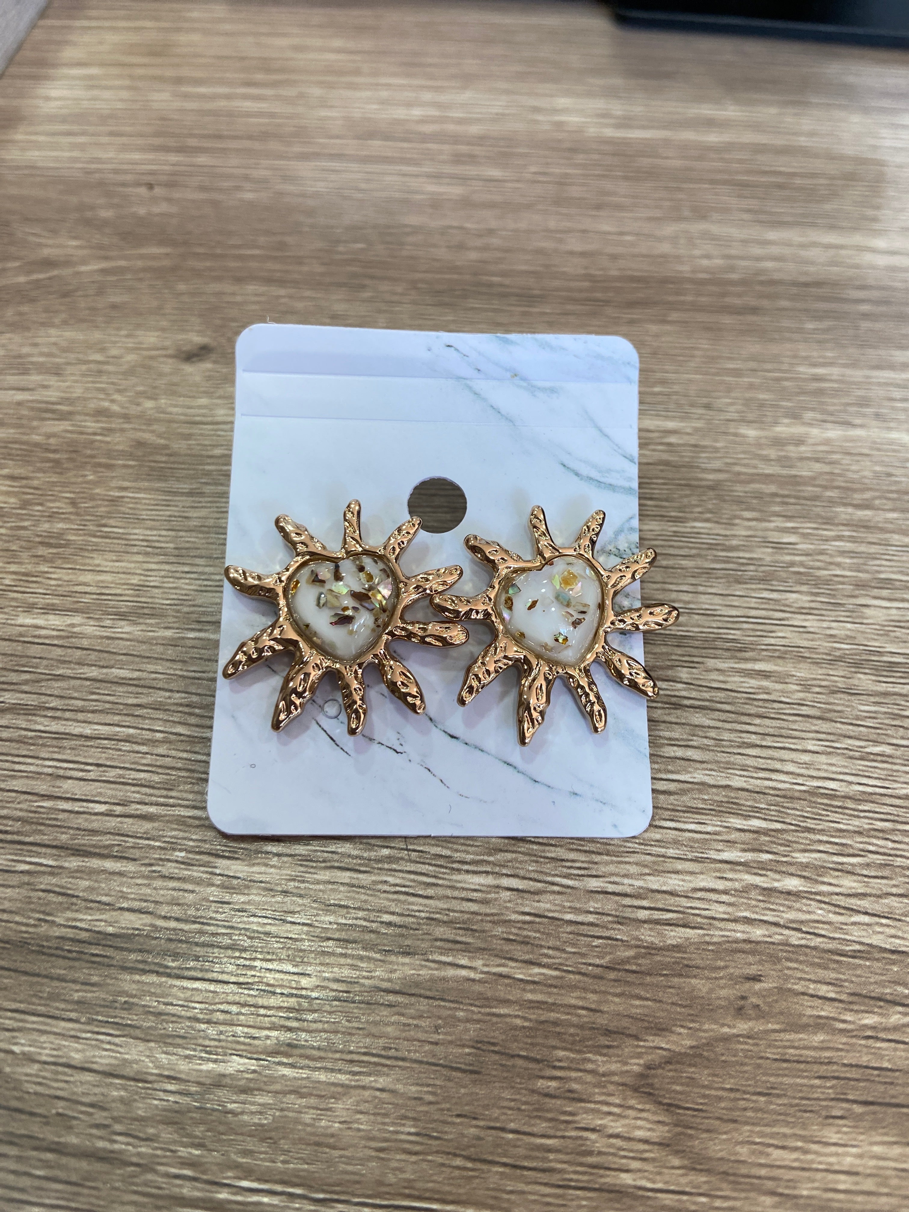 Aretes de corazón beige con excedente dorado