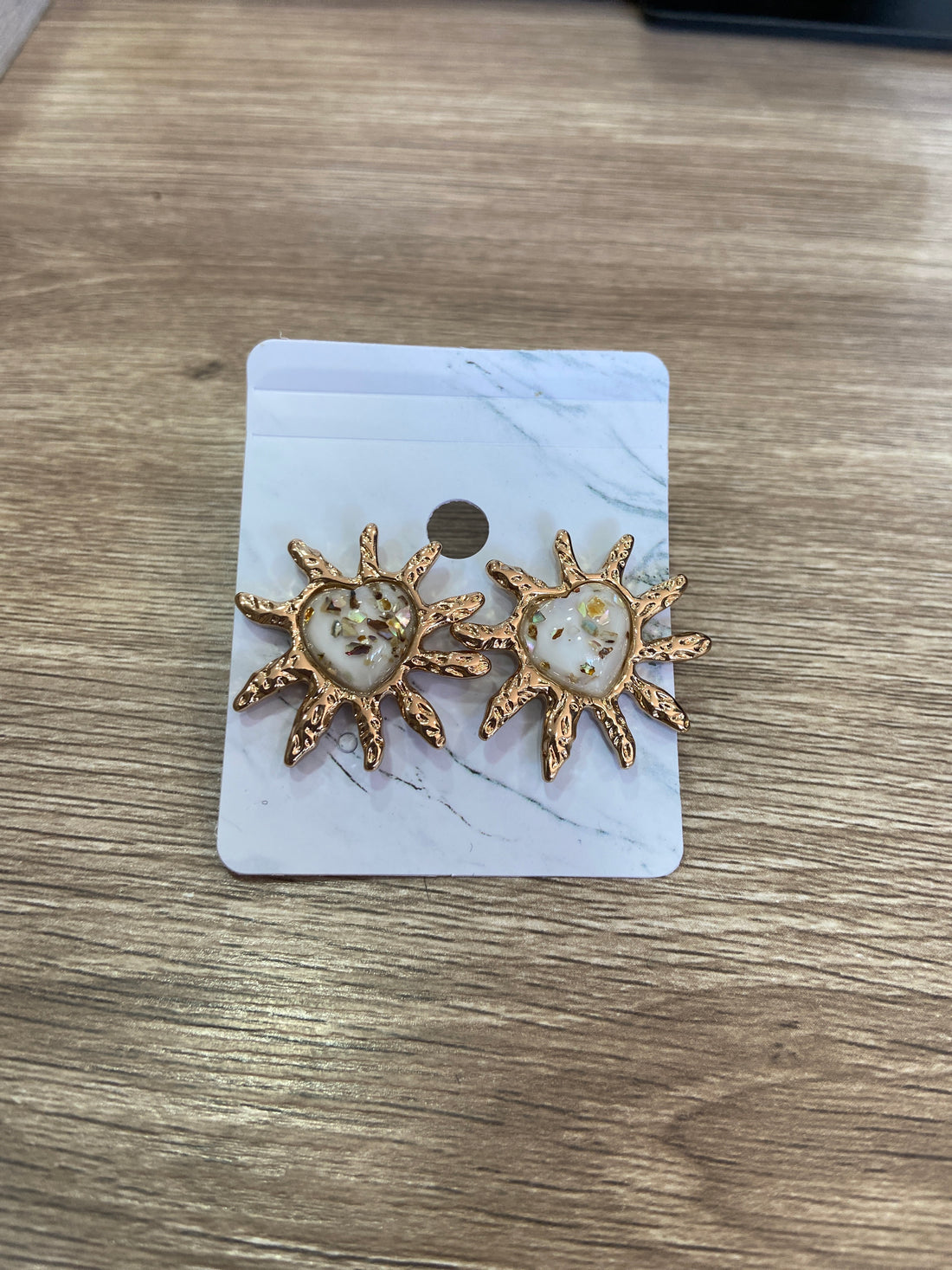 Aretes de corazón beige con excedente dorado