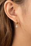 Aretes Huggie de Aro con Flor Colgante de Circonias en Oro Brillante