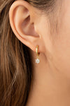 Aretes Huggie de Aro con Flor Colgante de Circonias en Oro Brillante