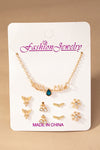 Conjunto de collar con dijes navide–os y 4 pares de tachuelas.