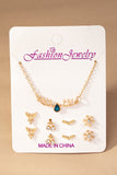 Conjunto de collar con dijes navide–os y 4 pares de tachuelas.
