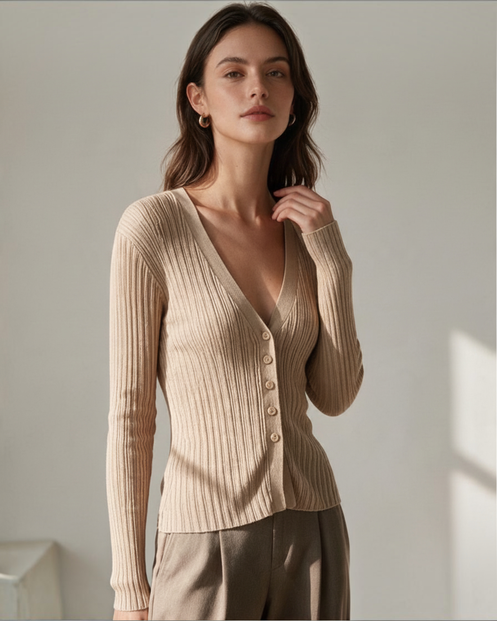 Modelo vistiendo cárdigan Yanet Collective de punto acanalado beige con escote en V y botones frontales