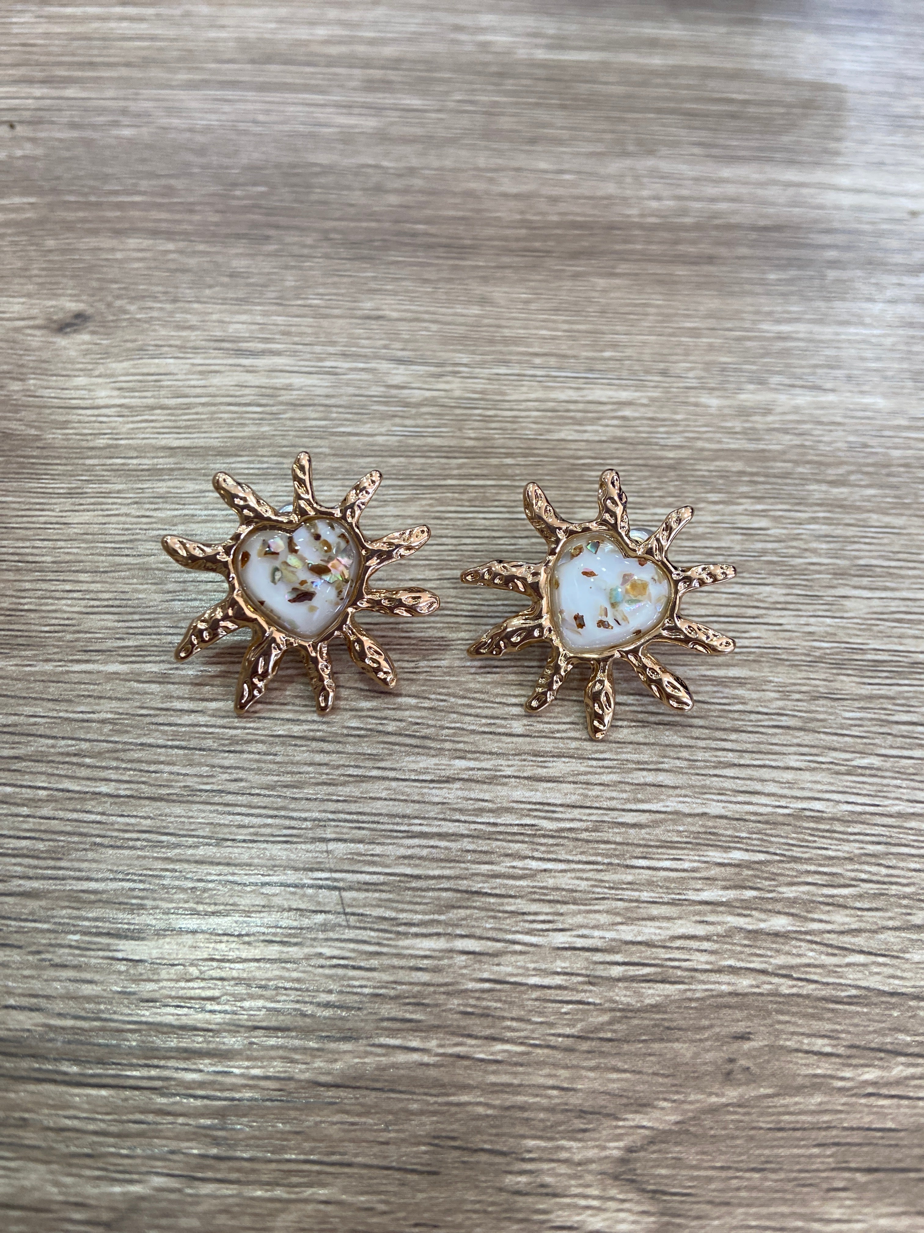 Aretes de corazón beige con excedente dorado