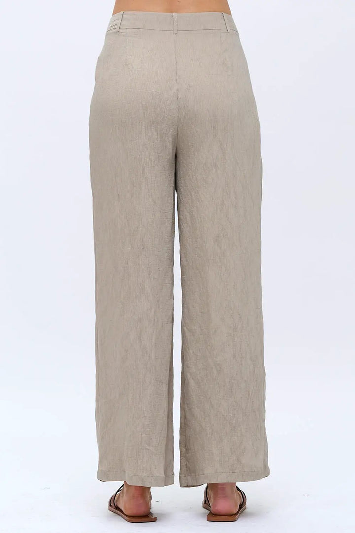 Pantalones de crepé de cintura alta con bajo acampanado beige by Yanet Collective