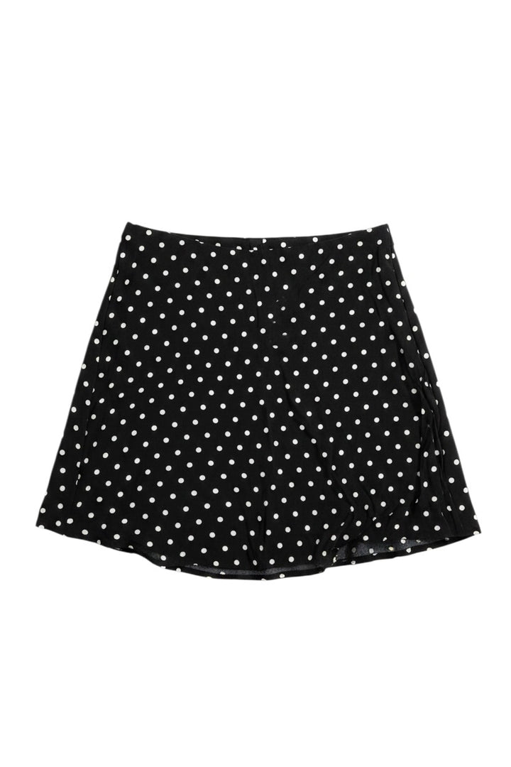 Yanet Collective black mini skirt with white polka dot pattern, featuring a flared silhouette.
