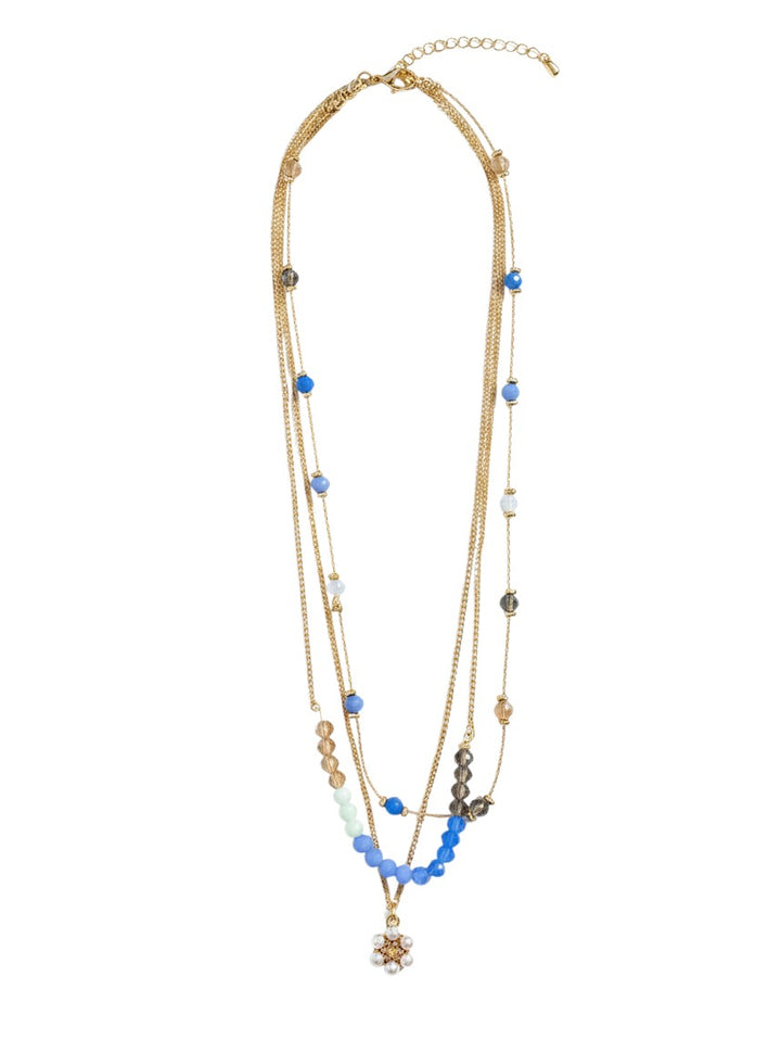 Yanet Collective multi-strand gold chain necklace featuring blue and clear beads with a floral pendant