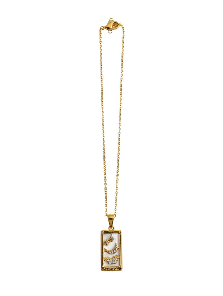 Yanet Collective gold necklace featuring a rectangular tarot card pendant with moon and star crystal accents.