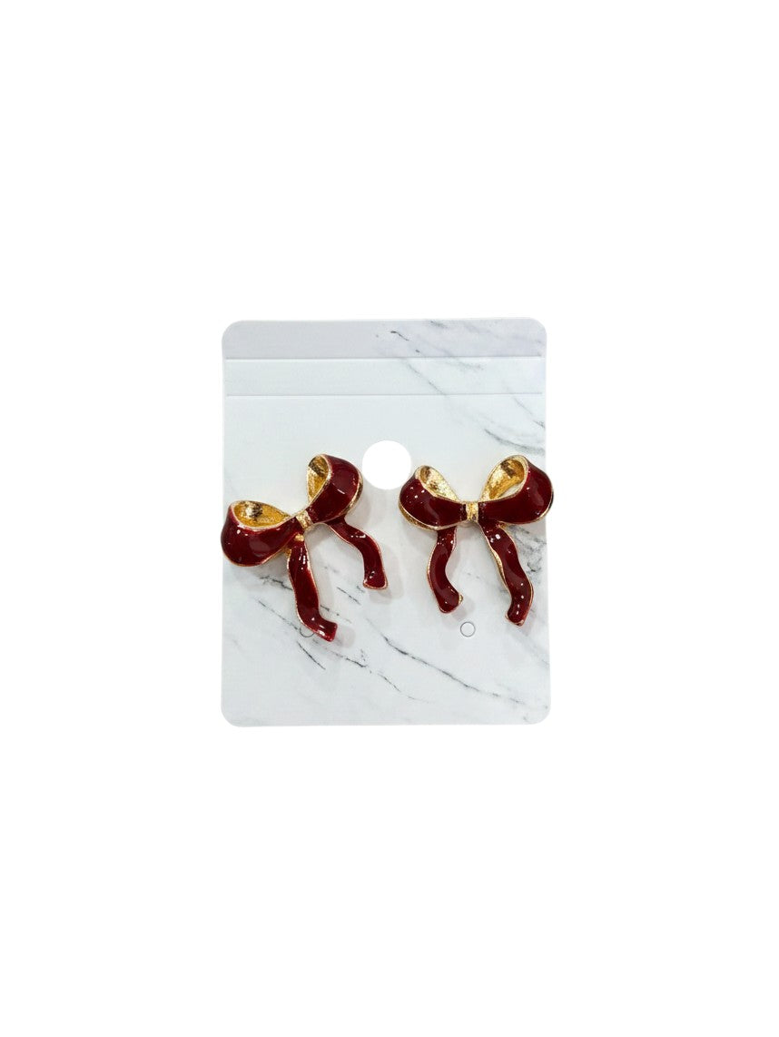 Yanet Collective red bow earrings with gold trim on a marble display card