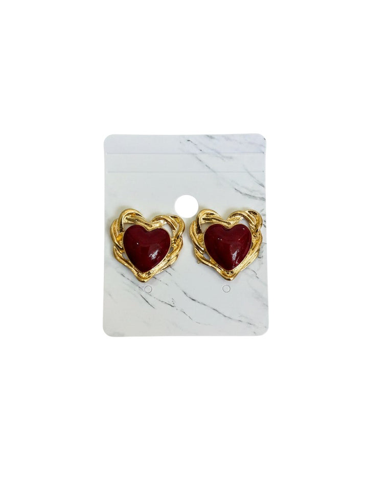 Yanet Collective heart-shaped stud earrings with a deep red center and textured gold-tone metal frame on display card