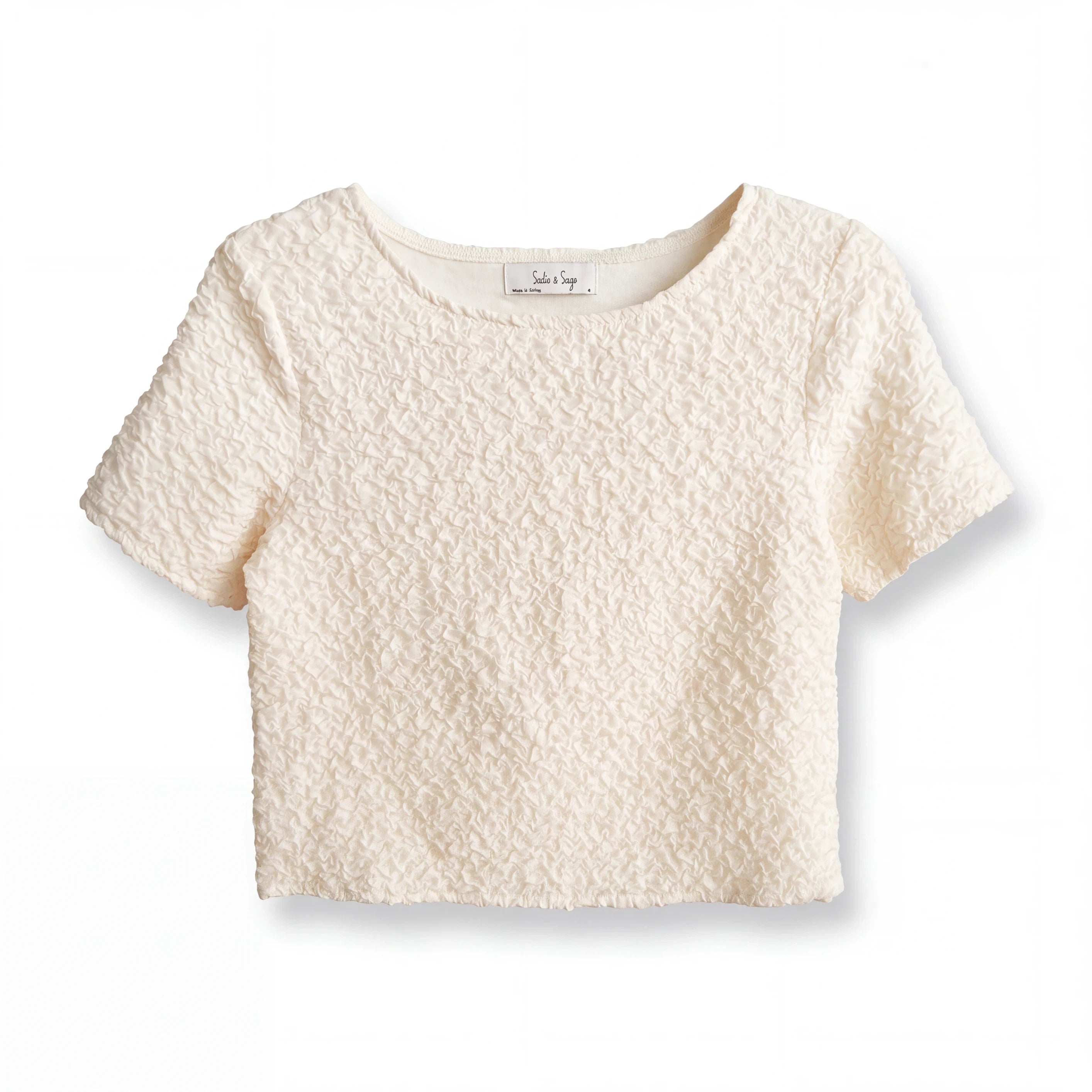 Top corto Yanet Collective color crema con textura arrugada, cuello redondo y mangas cortas en diseño minimalista