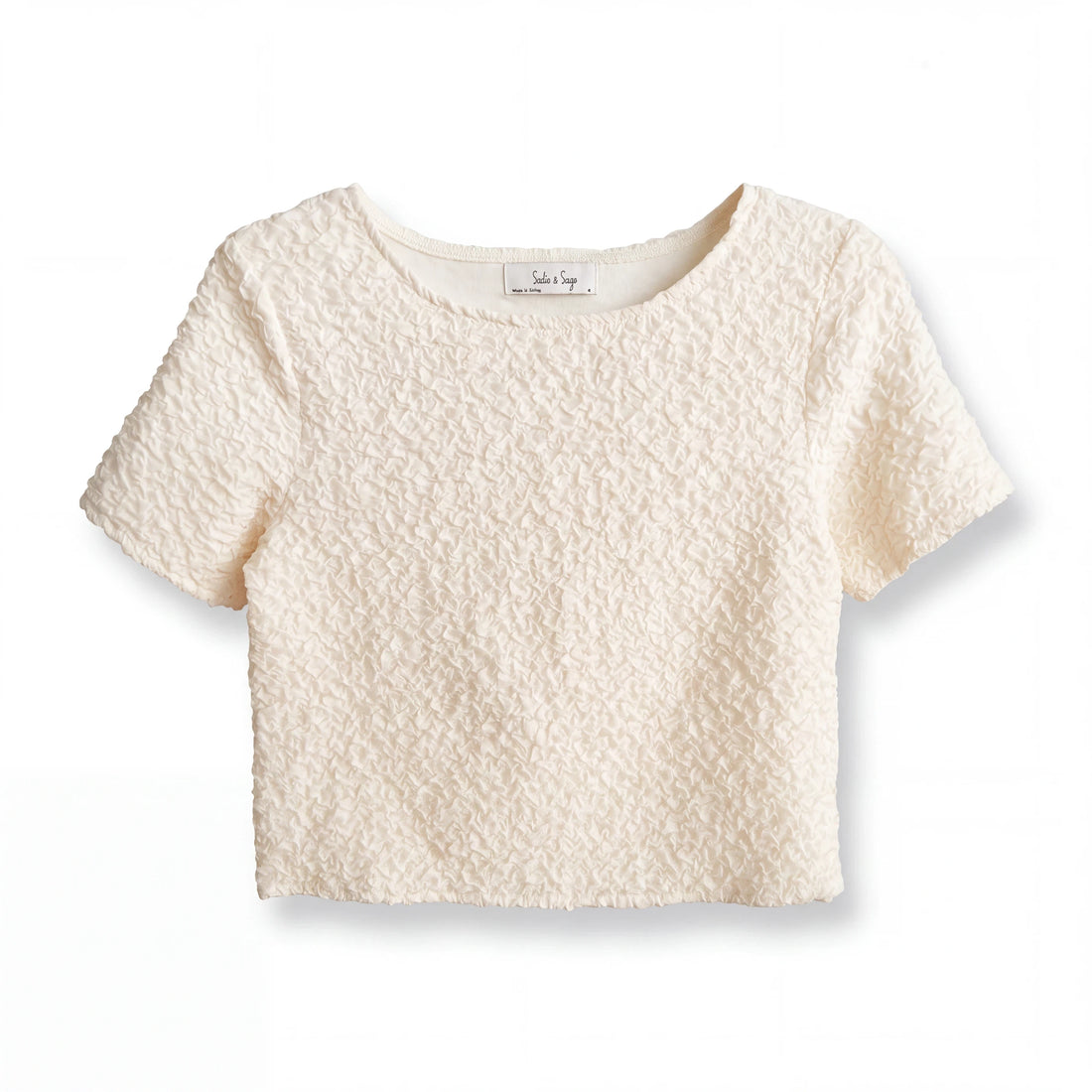 Top corto Yanet Collective color crema con textura arrugada, cuello redondo y mangas cortas en diseño minimalista