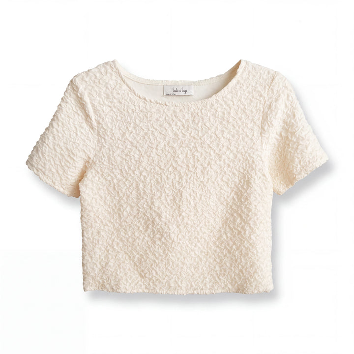 Top corto Yanet Collective color crema con textura arrugada, cuello redondo y mangas cortas en diseño minimalista