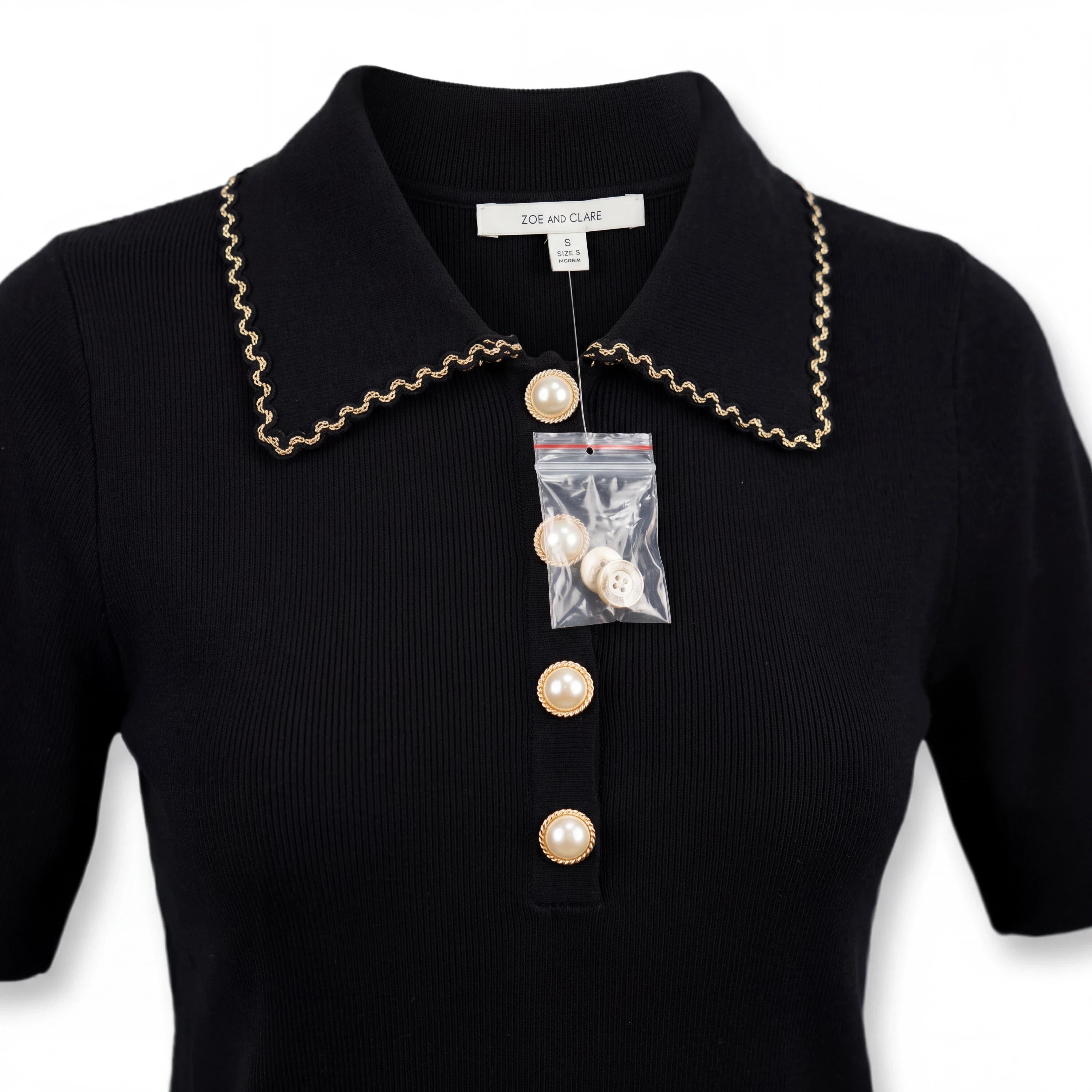 Top de punto negro Yanet Collective con cuello de solapa, ribete en contraste y botones perlados frontales